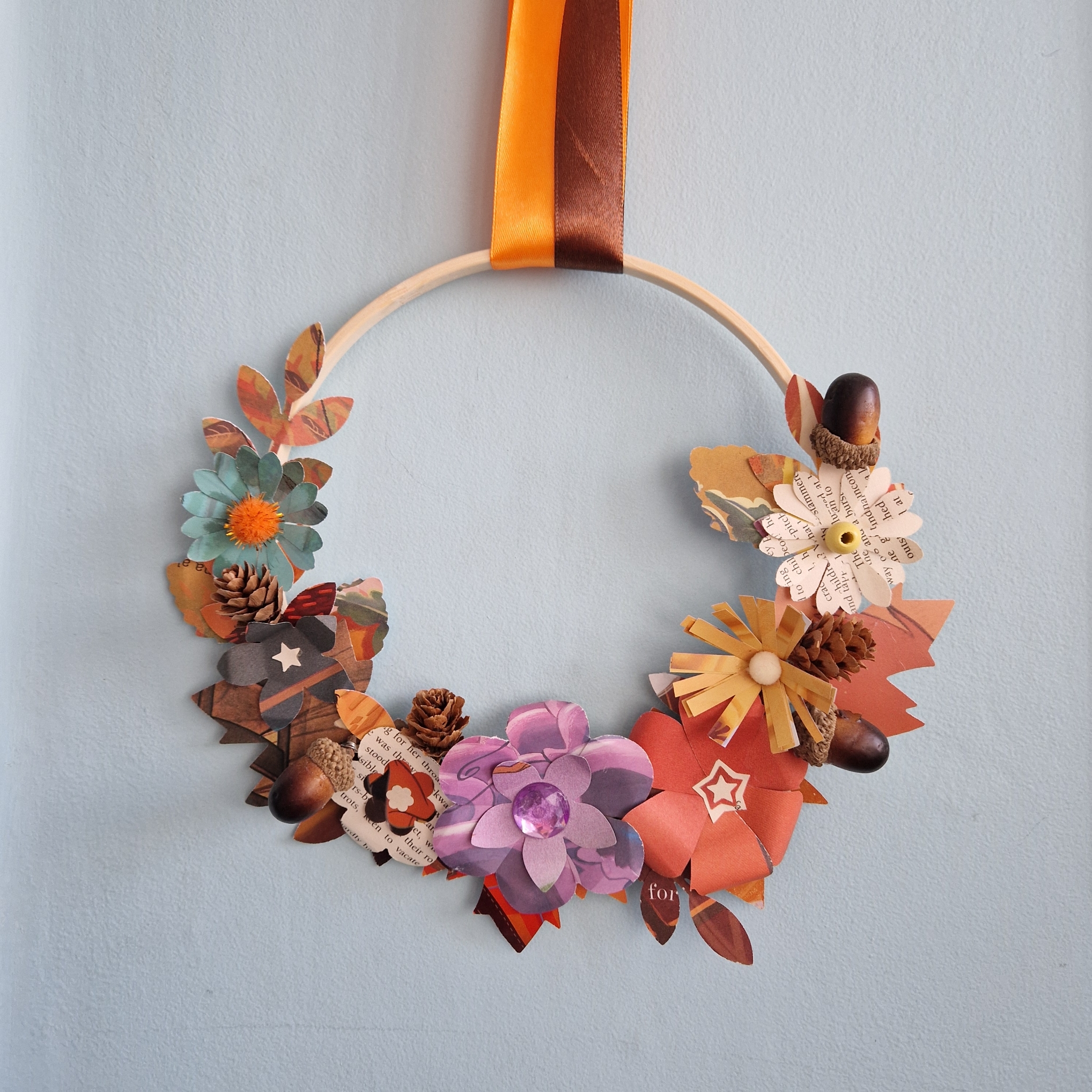 A wreath decorated in colourful autumnal flowers made from paper