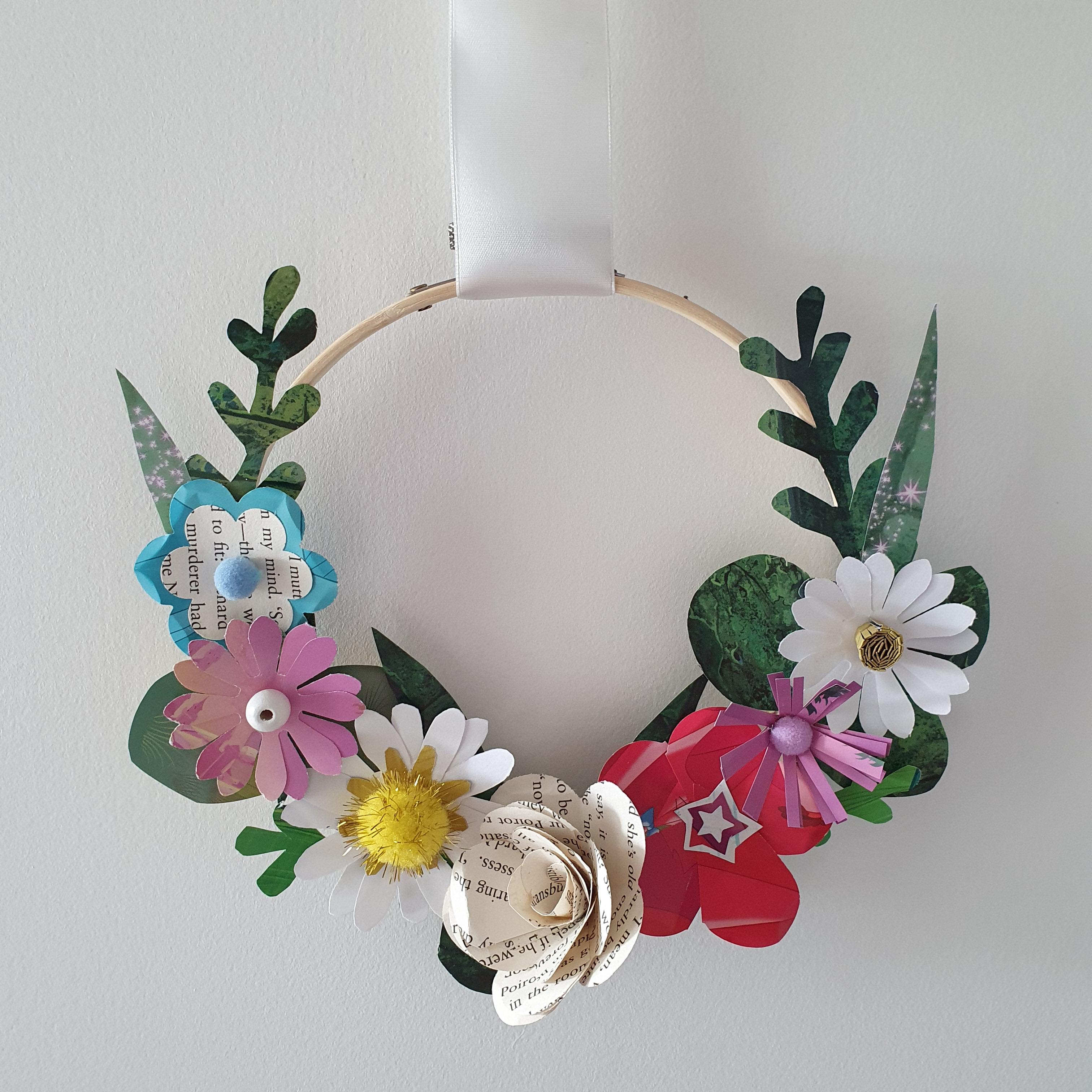 A wreath decorated in colourful autumnal flowers made from paper