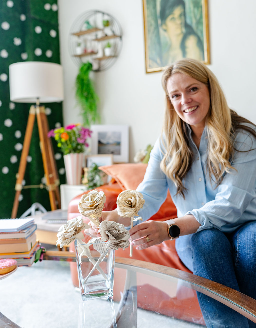 Woman in her 40s is displaying a vase of roses made from book pages