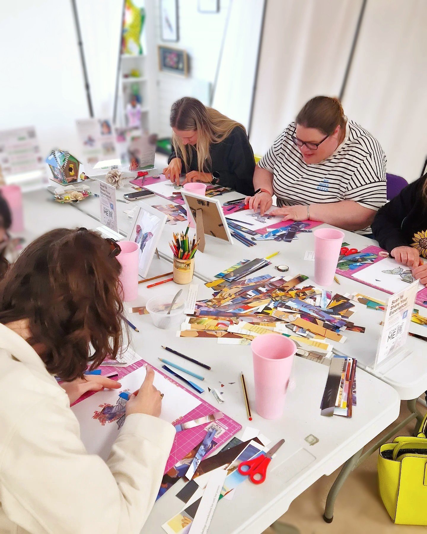 A group of women in their 30s sitting around a table crafting