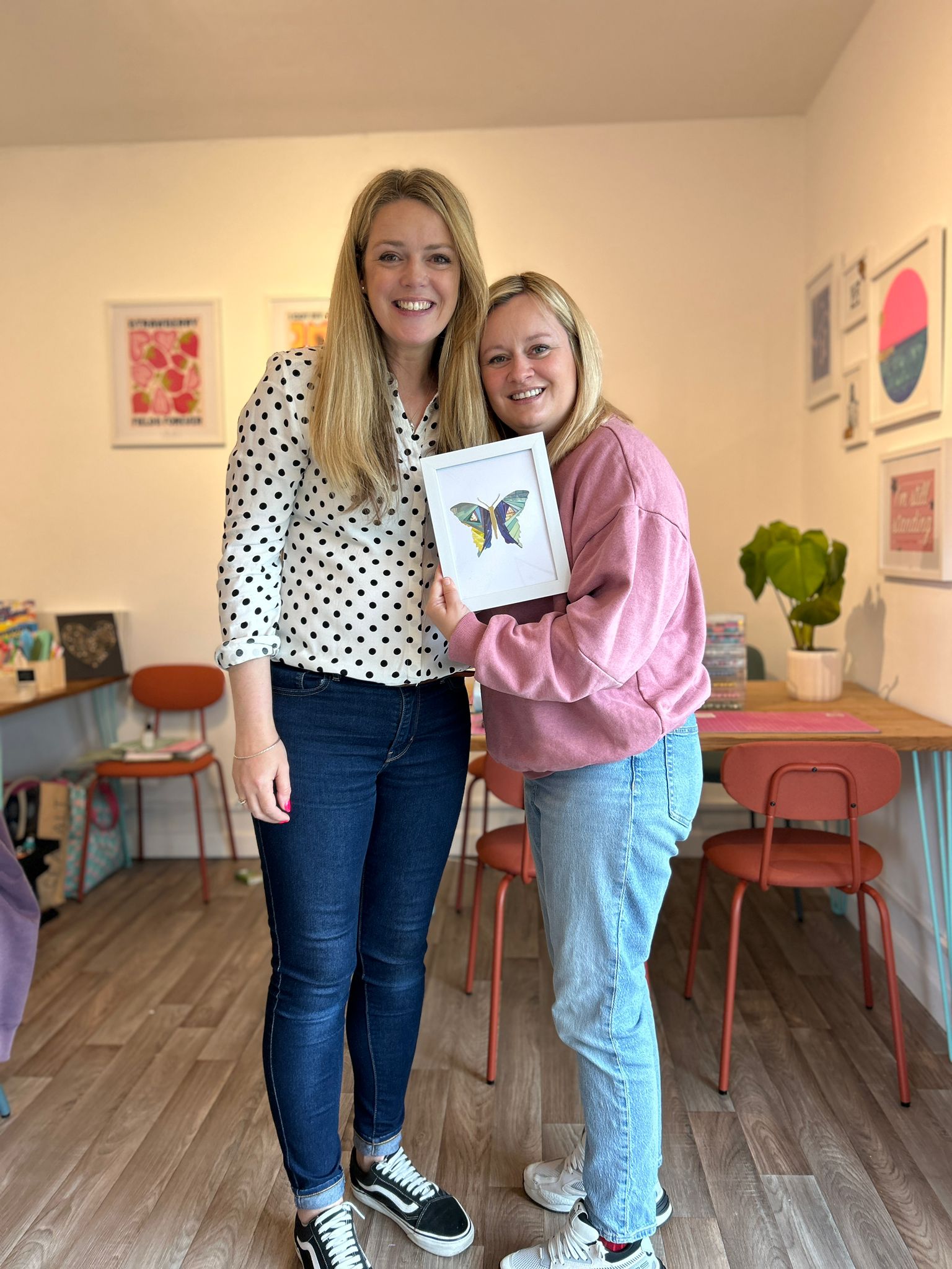 Business Owner Becky is standing with client holding the iris paper folded butterfly picture she has made